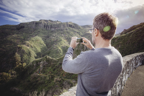 Spanien, Kanarische Inseln, Gran Canaria, Mann beim Fotografieren der Vega de San Mateo, lizenzfreies Stockfoto