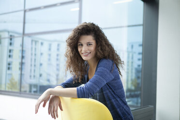 Portrait of smiling young woman at the window - RBF002314