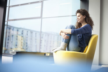 Entspannte junge Frau mit Blick auf das Fenster - RBF002330