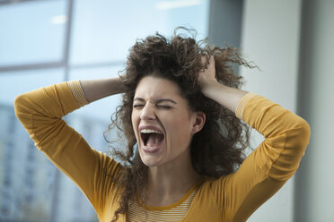 Screaming young woman with hands in hair - RBF002343