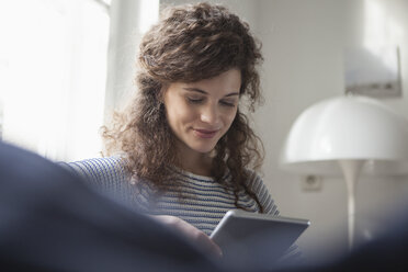 Junge Frau zu Hause mit digitalem Tablet - RBF002292