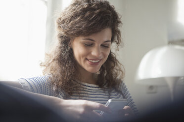 Young woman at home looking at cell phone - RBF002294