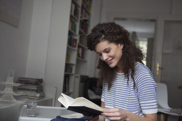 Junge Frau zu Hause beim Lesen eines Buches - RBF002300