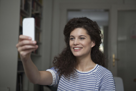 Junge Frau zu Hause, die ein Selfie macht, lizenzfreies Stockfoto