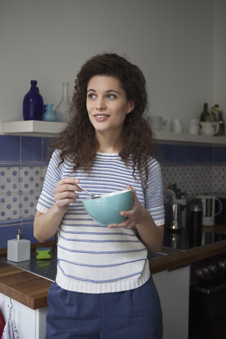 Junge Frau in der Küche mit Müslischale, lizenzfreies Stockfoto