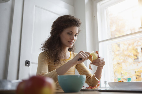 Young woman peeling an apple stock photo