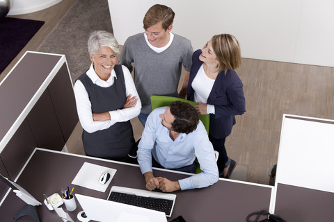 Smiling business team at desk in office stock photo