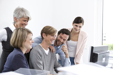 Glückliches Business-Team am Schreibtisch im Büro - MFRF000027