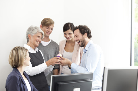 Geschäftsteam feiert einen Geburtstag im Büro, lizenzfreies Stockfoto