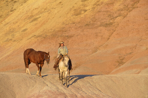 USA, Wyoming, Cowgirl mit zwei Pferden in den Badlands - RUEF001435