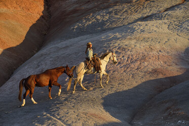 USA, Wyoming, Cowgirl mit zwei Pferden in den Badlands - RUEF001438