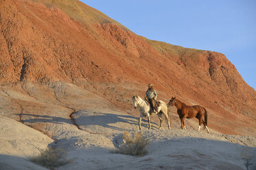 USA, Wyoming, Cowgirl mit zwei Pferden in den Badlands - RUEF001439
