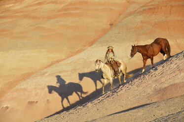 USA, Wyoming, Cowgirl mit zwei Pferden in den Badlands - RUEF001441