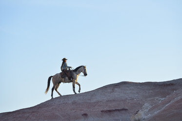 USA, Wyoming, Cowgirl reitet in den Badlands - RUEF001444