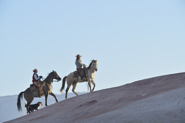 USA, Wyoming, zwei reitende Cowgirls und ihr Hund in den Badlands - RUEF001446