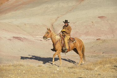 USA, Wyoming, Cowboyreiten in den Badlands - RUEF001450