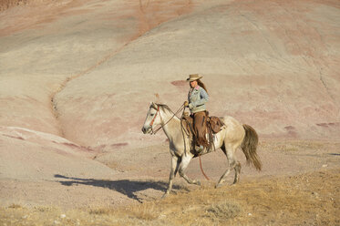 USA, Wyoming, Cowgirl reitet in den Badlands - RUEF001451