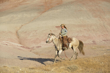 USA, Wyoming, cowgirl riding in badlands - RUEF001451