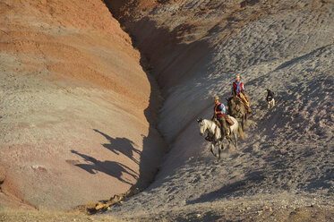 USA, Wyoming, Cowgirl und Cowboy reiten in den Badlands - RUEF001454