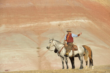 USA, Wyoming, Cowboy mit zwei Pferden in den Badlands - RUEF001457