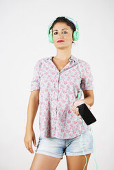 Portrait of woman with smartphone and headphones listening music - GEMF000020