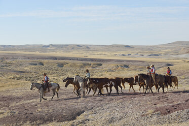 USA, Wyoming, Cowboys und Cowgirls führen Pferde in den Badlands - RUEF001472