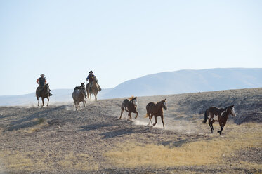 USA, Wyoming, zwei Cowboys hüten Pferde in den Badlands - RUEF001473