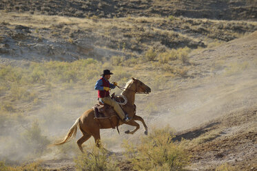 USA, Wyoming, Cowboyreiten in den Badlands - RUEF001474