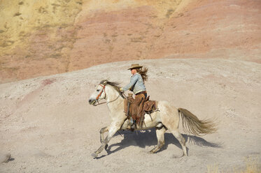 USA, Wyoming, cowgirl riding in badlands - RUEF001481