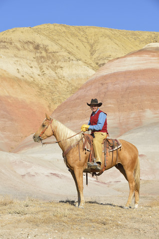 USA, Wyoming, Cowboy auf seinem Pferd in den Badlands, lizenzfreies Stockfoto