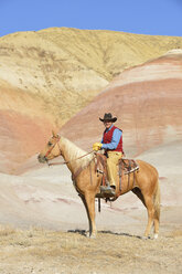 USA, Wyoming, Cowboy auf seinem Pferd in den Badlands - RUEF001483