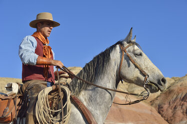 USA, Wyoming, Cowboy auf seinem Pferd in den Badlands - RUEF001484