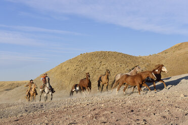 USA, Wyoming, zwei Cowboys hüten Pferde in den Badlands - RUEF001513