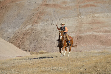 USA, Wyoming, Big Horn Mountains, riding cowboy swinging lasso - RUEF001491