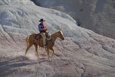 USA, Wyoming, cowboy riding in badlands - RUEF001499