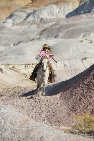 USA, Wyoming, Cowgirl reitet in den Badlands, lizenzfreies Stockfoto