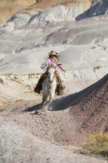 USA, Wyoming, Cowgirl reitet in den Badlands - RUEF001500