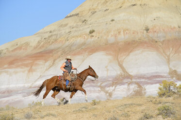 USA, Wyoming, Cowboyreiten in den Badlands - RUEF001506