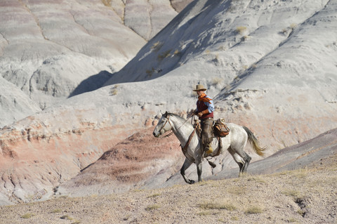 USA, Wyoming, Cowboyreiten in den Badlands, lizenzfreies Stockfoto