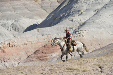 USA, Wyoming, cowboy riding in badlands - RUEF001508