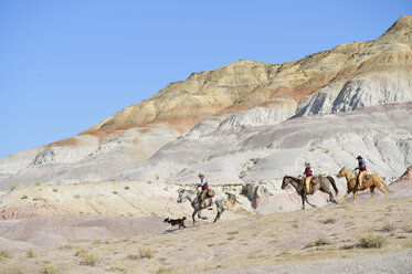 USA, Wyoming, zwei Cowboys und ein Cowgirl reiten in den Badlands - RUEF001510