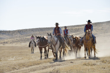 USA, Wyoming, Cowboys und Cowgirls führen Pferde in den Badlands - RUEF001512