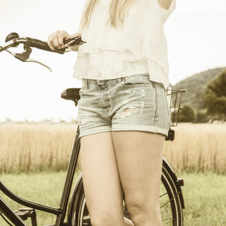 Deutschland, Junge Frau mit Fahrrad und Hotpants - DRF001253