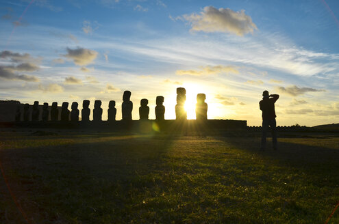 Chile, Osterinsel, Reihe von Moais am Ahu Tongariki bei Sonnenuntergang, Tourist beim Fotografieren - GEMF000201