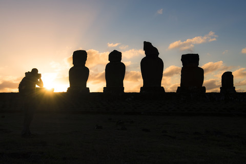 Chile, Osterinsel, Mann fotografiert Moais bei Sonnenuntergang, Ahu Tahai Complex, Rapa Nui National Park, lizenzfreies Stockfoto