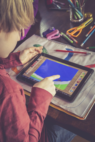 Boy using digital tablet for drawing stock photo