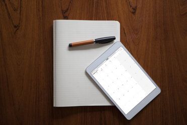 Digitales Tablet und Kugelschreiber liegen auf einem aufgeschlagenen Notizbuch - RBF002432