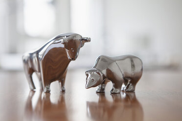 Miniaturskulpturen von Stier und Bär auf einem Schreibtisch - RBF002436