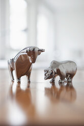 Miniaturskulpturen von Stier und Bär auf einem Schreibtisch - RBF002437