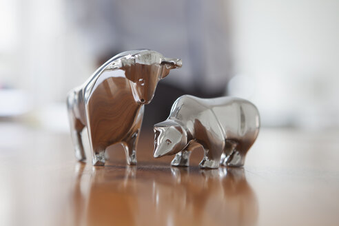 Miniaturskulpturen von Stier und Bär auf einem Schreibtisch - RBF002451